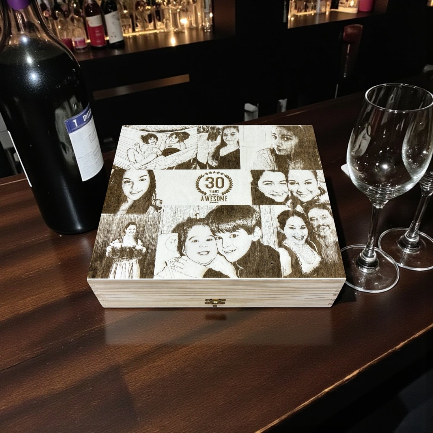 Warmly lit beeswax candle next to a rustic brown paper gift box tied with twine on dark wood.